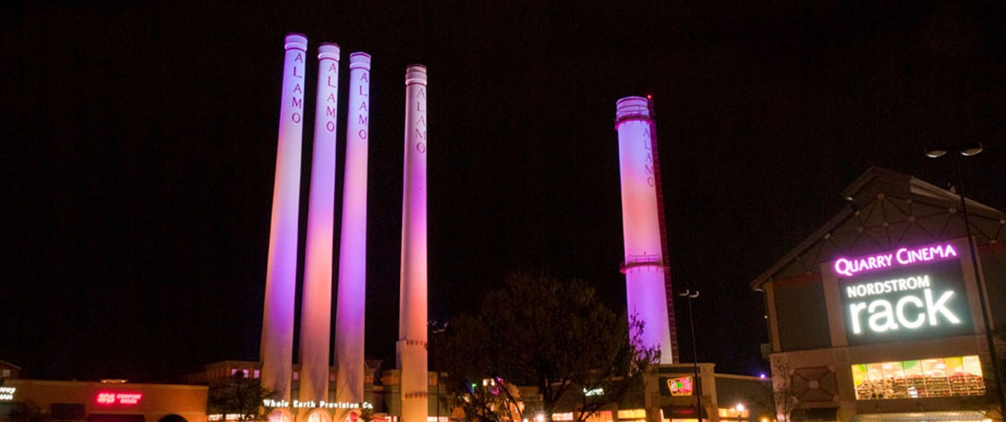 Illuminated Alamo Quarry smokestacks near Alamo Heights at night