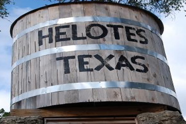 Historic wooden water tank marked Helotes Texas