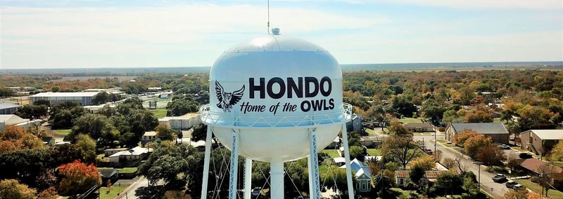 Hondo water tower displaying Home of the Owls above the surrounding community
