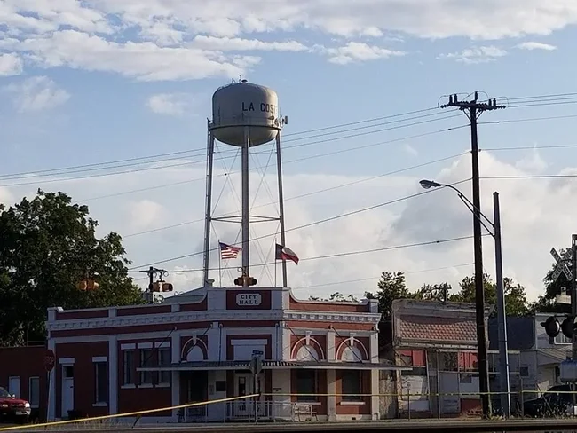 La Coste water tower above City Hall with American and Texas flags