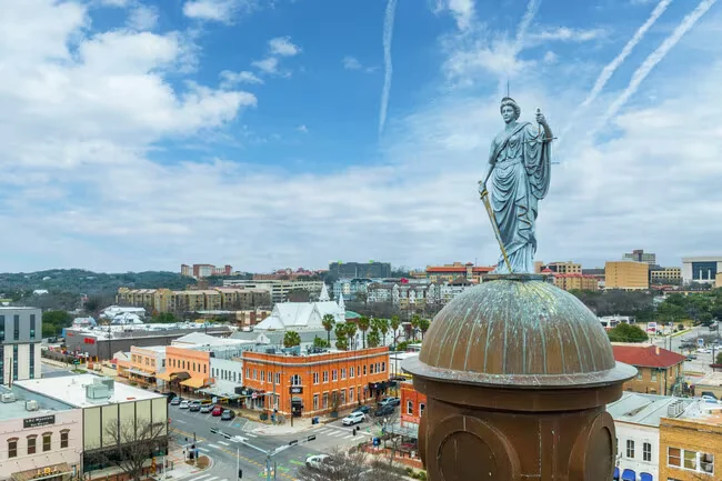 View of downtown San Marcos with a statue above a courthouse dome