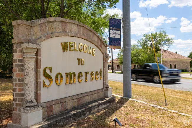 Welcome to Somerset stone entrance sign beside a tree-lined street